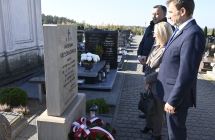 grupa osób stojących przed pomnikiem