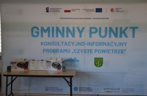 stolik z nagrodami na tle scianki z niebieskimi napisami