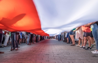 flaga polski trzymana przez ludzi
