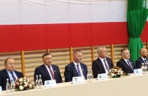 grupa mezczyzn w garniturach w tle flaga polski