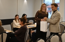 Kobieta trzyma biala torebke, stojac obok mezczyzny