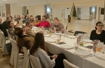 Grupa siedzacych przy stole ludzi