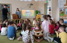 grupa dzieci siedzi na dywanie 