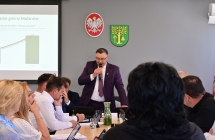 na drugim planie przewodniczacy rady gminy trzyma mikrofon, na pierwszym planie radni