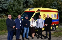 grupa osób stojąca przy karetce